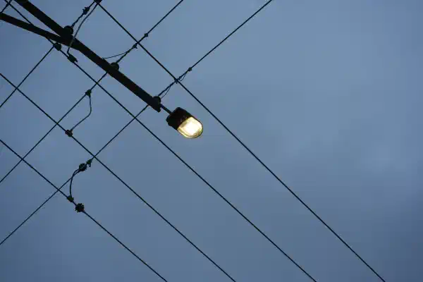 A streetlight shot from below, with two sets of parallel wires running at 90 degrees to each other.