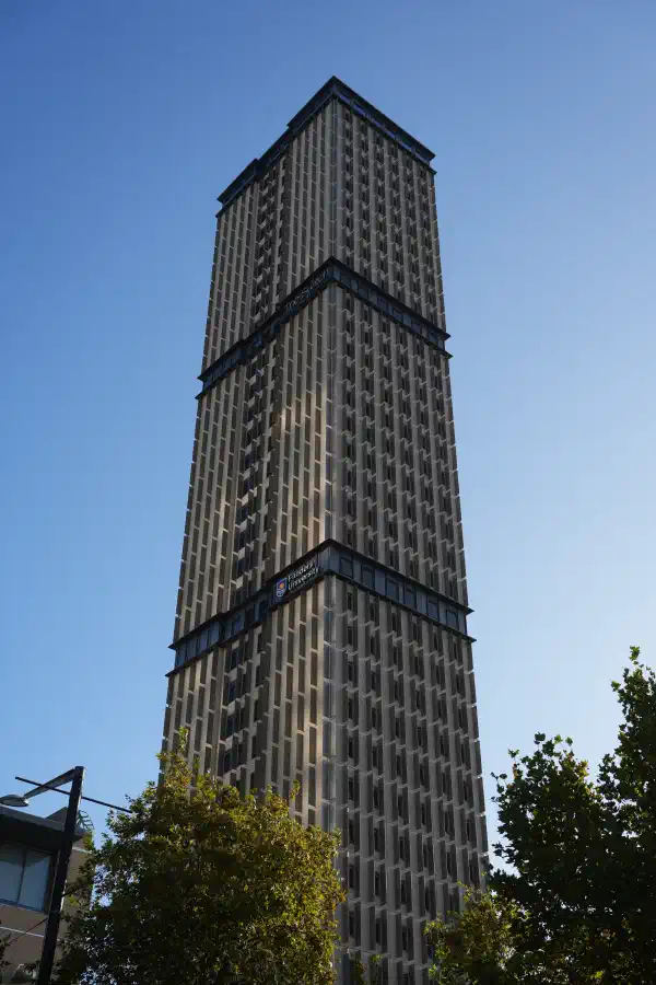 A tall building from ground level, blue sky is above