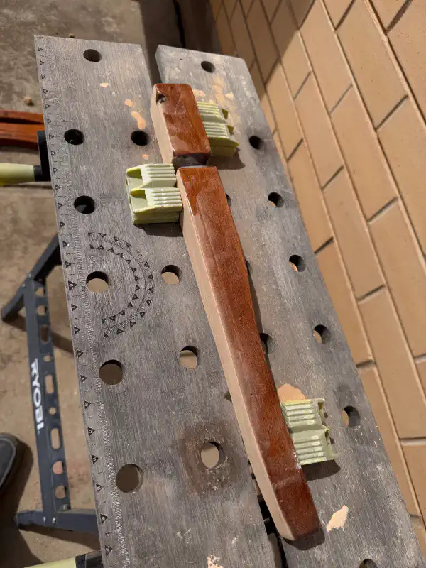 Table leg on sawhorse, held in place with clamps