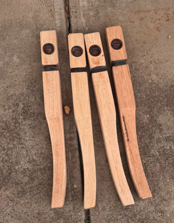 four table legs on the ground, sanded to bare wood
